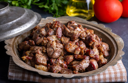 Muslims Traditional Sacrifice holiday food lamb, Turkish roasted meat in copper pot on table top. Turkish Kavurma