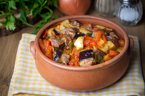 Top view of Turkish dish Guvech - baked meat with eggplant and traditionally served in earthenware pot (Turkish name; etli patlican guvec)